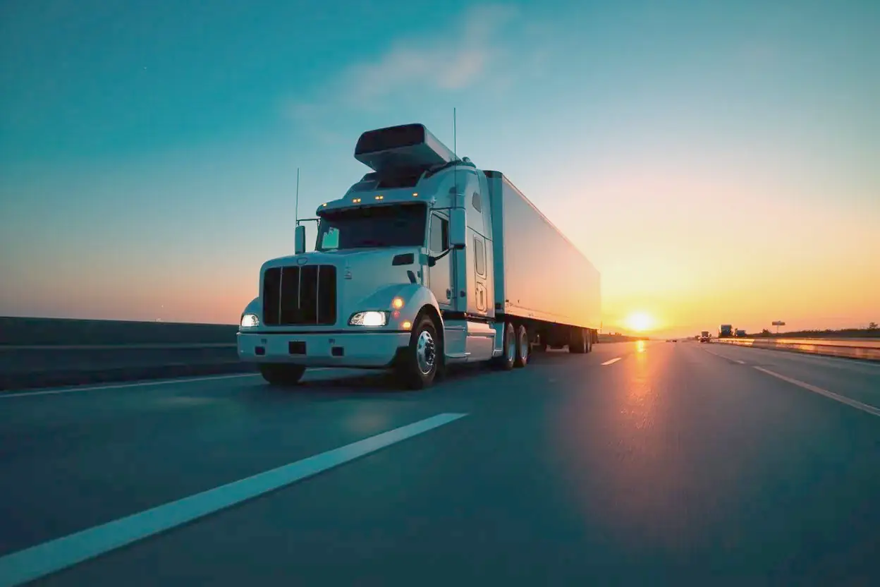 A sensor equipped semi truck drives an empty highway at sunrise